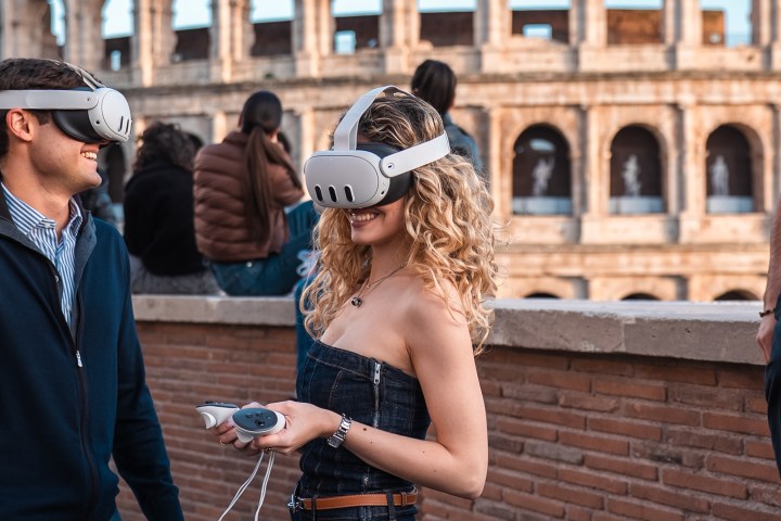Two people wearing VR headsets near the Colosseum in Rome.