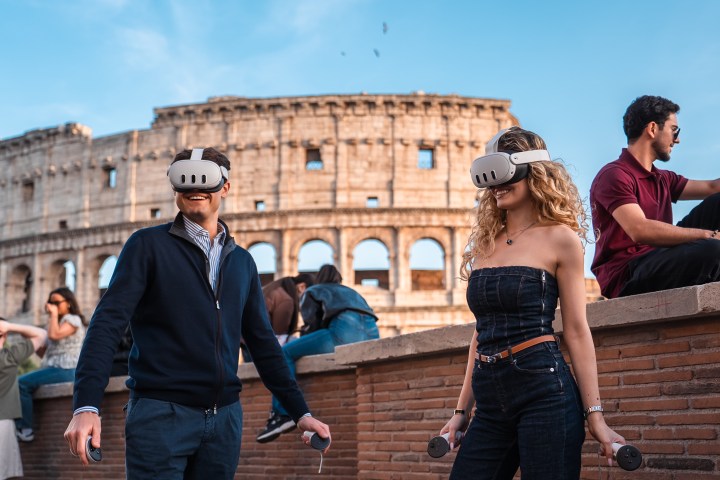 Two people with VR headsets and controllers near the Colosseum.